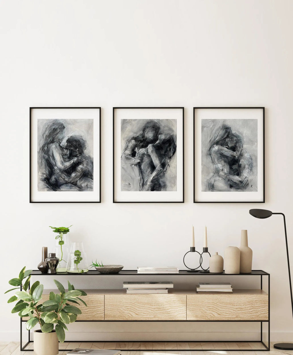 Set of three black and white oil paintings hanging above a bed