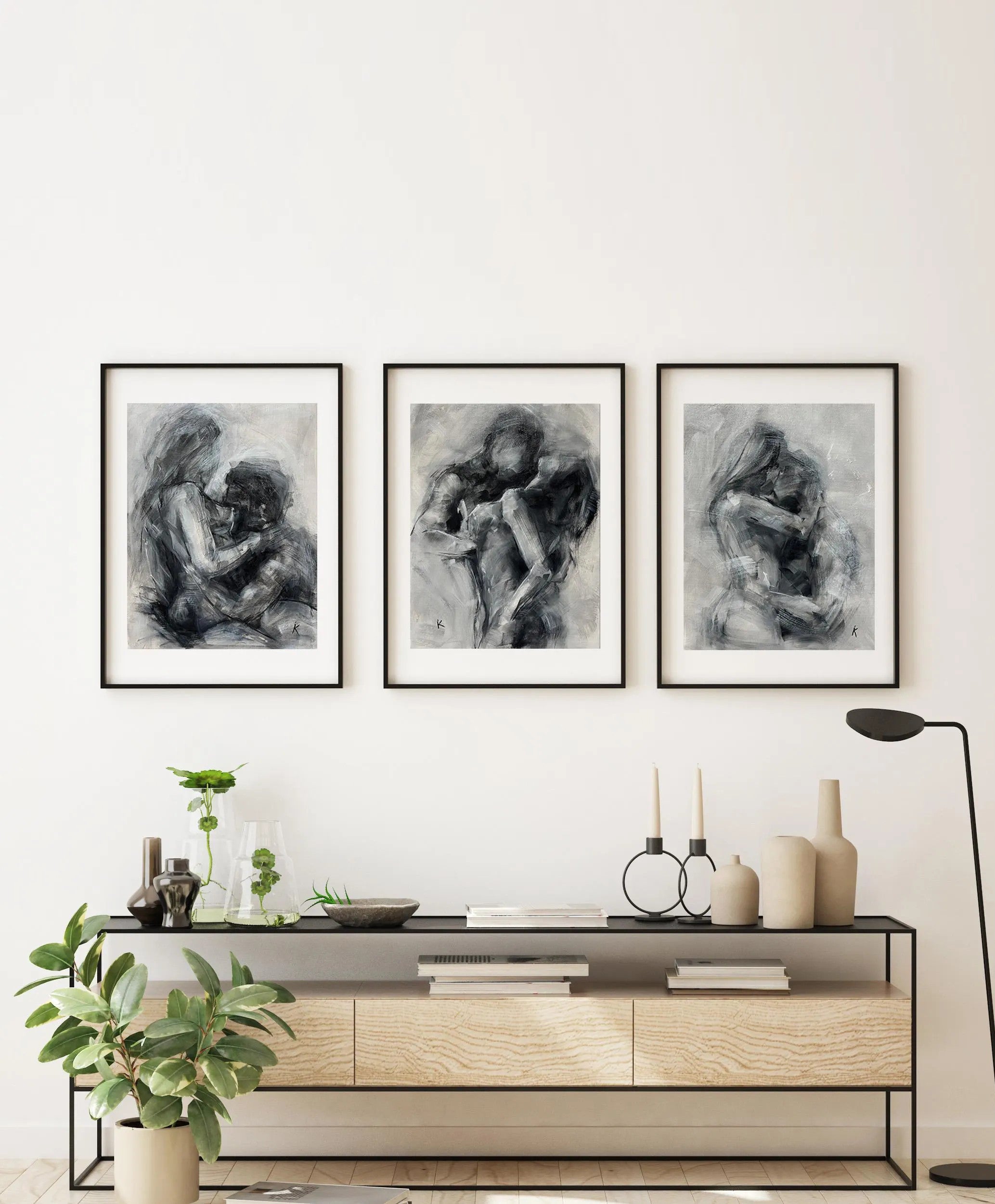 Set of three black and white oil paintings hanging above a bed
