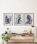 Set of three monochrome figurative paintings on a light wall